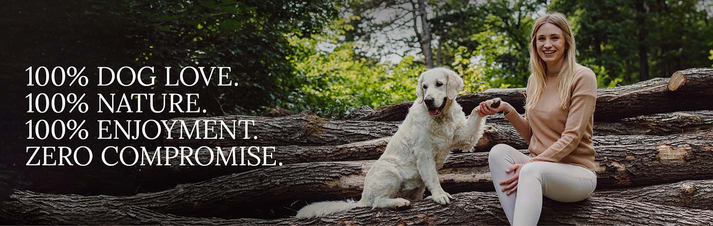 Katharina Miklauz with her dog Nala is sitting on tree trunks