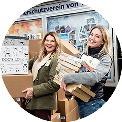 Frauke Ludiwig und Katharina Miklauz wie sie gerade DOG'S LOVE Produkte in der Hand halten und spenden.